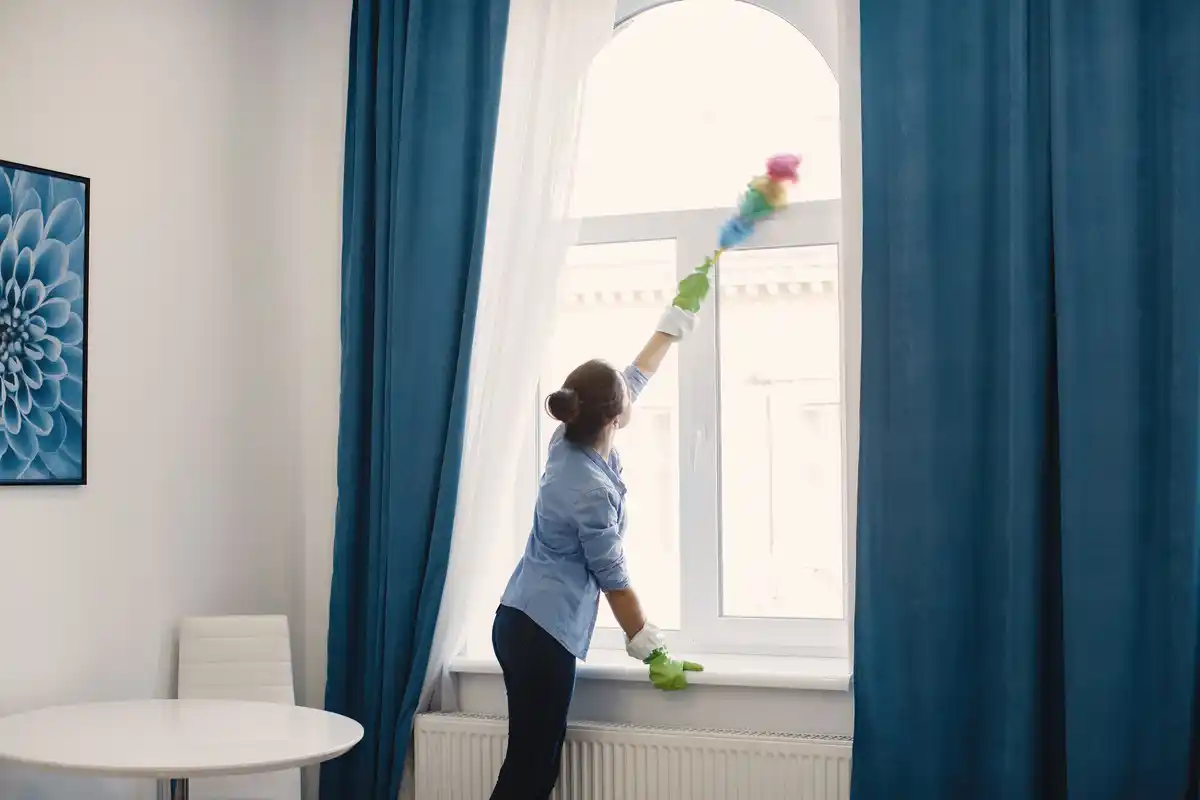 scandinavian woman vinegar cleaning window minimalistic home