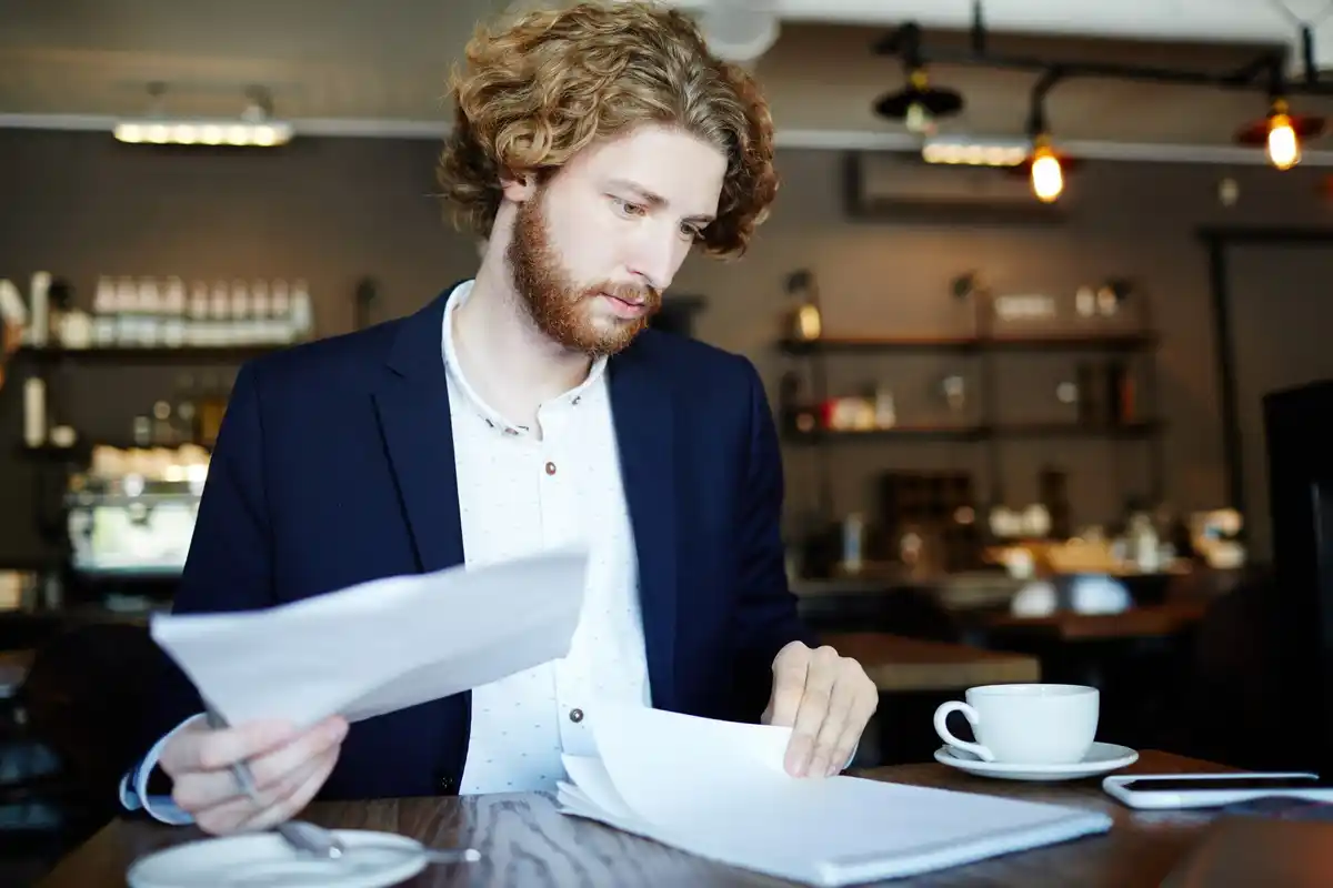 comparing czech bank account fees, person looking at contracts, magnifying glass over bank statement