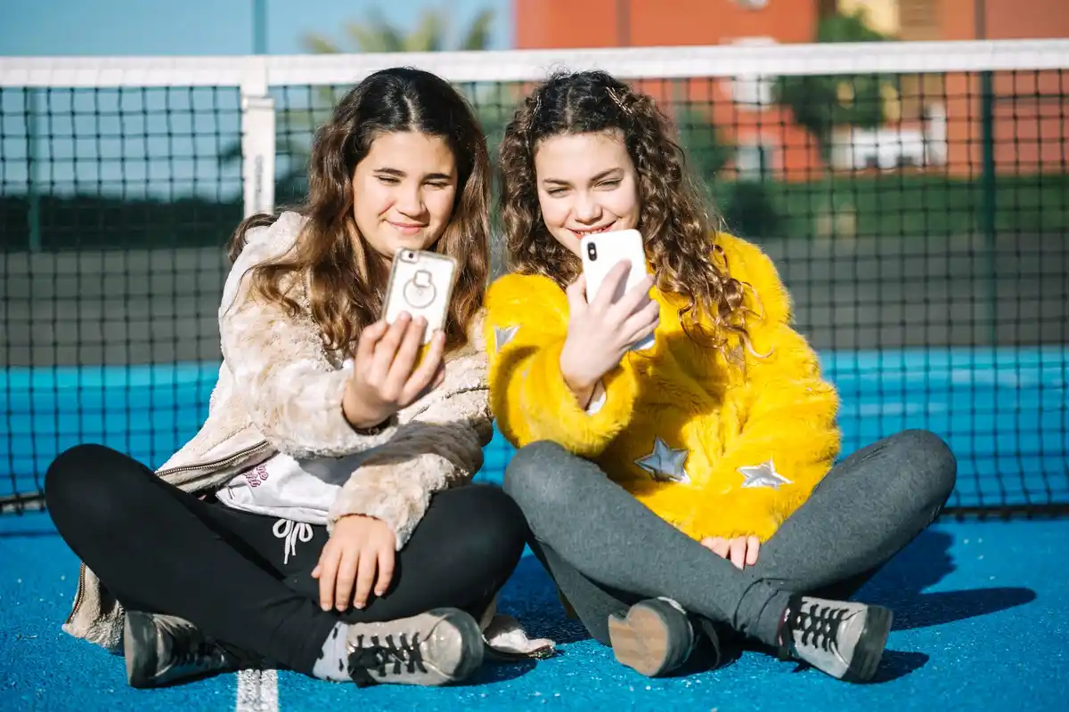 Czech teens chatting on smartphones outdoors