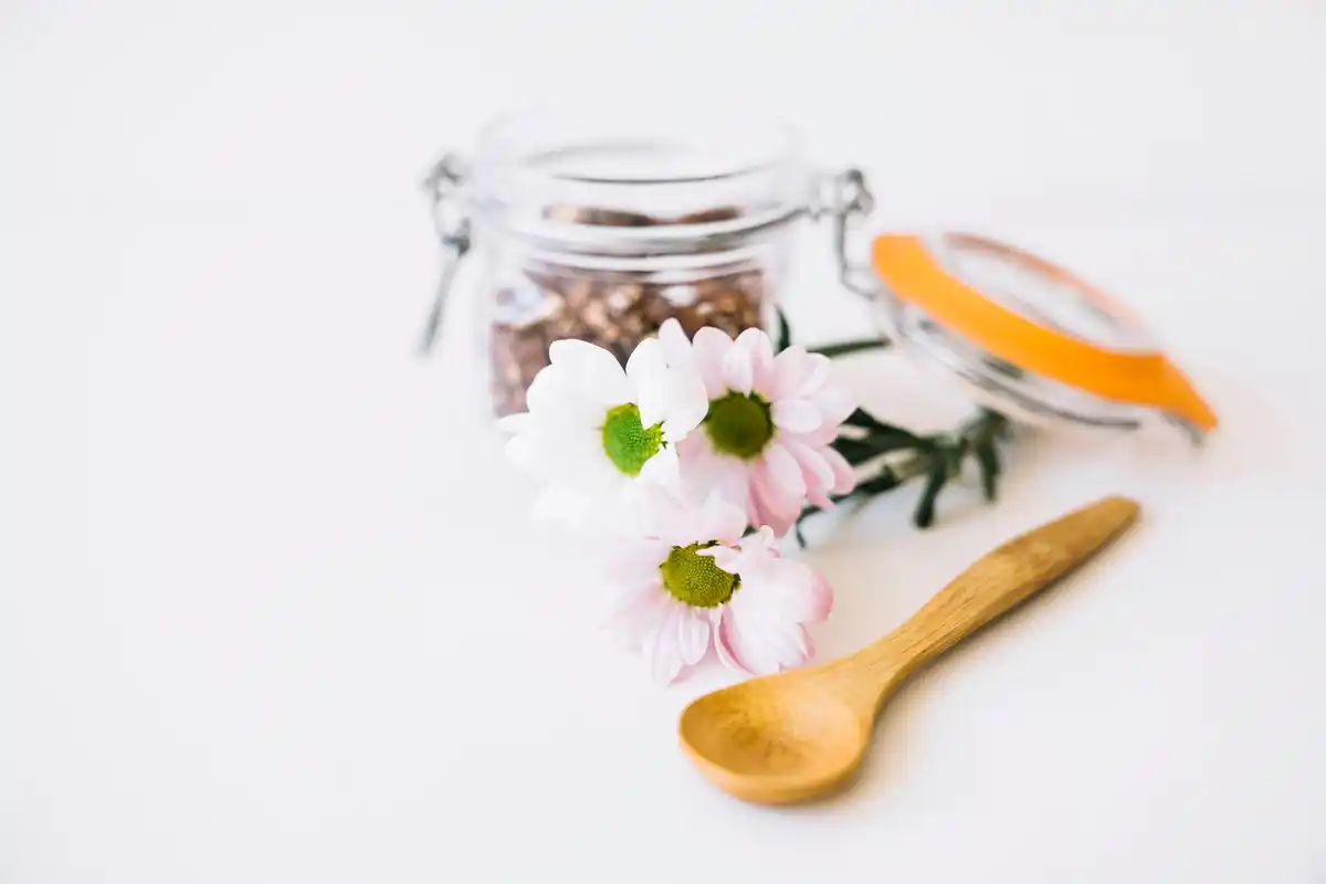 homemade coffee scrub in jar with wooden spoon, natural skincare concept