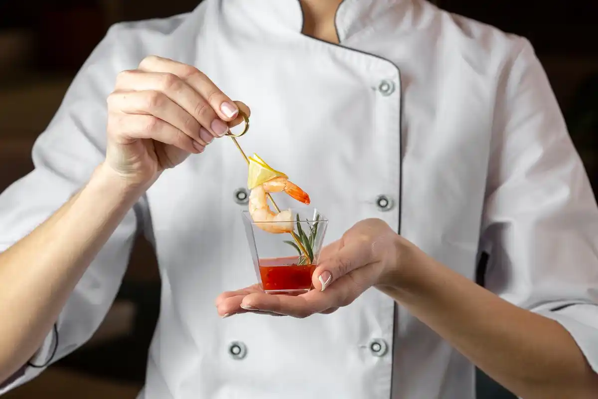 chef adding spices to dish close up