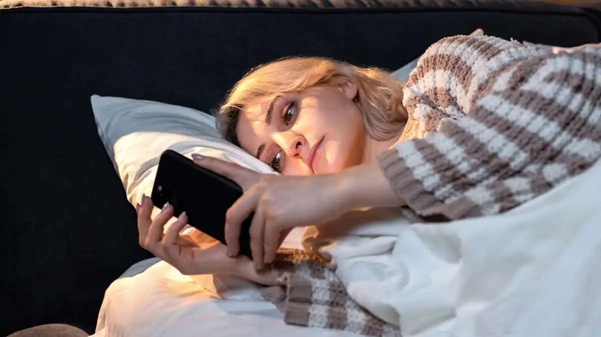 charging phone at night, close-up, in bed, cozy night, dark background