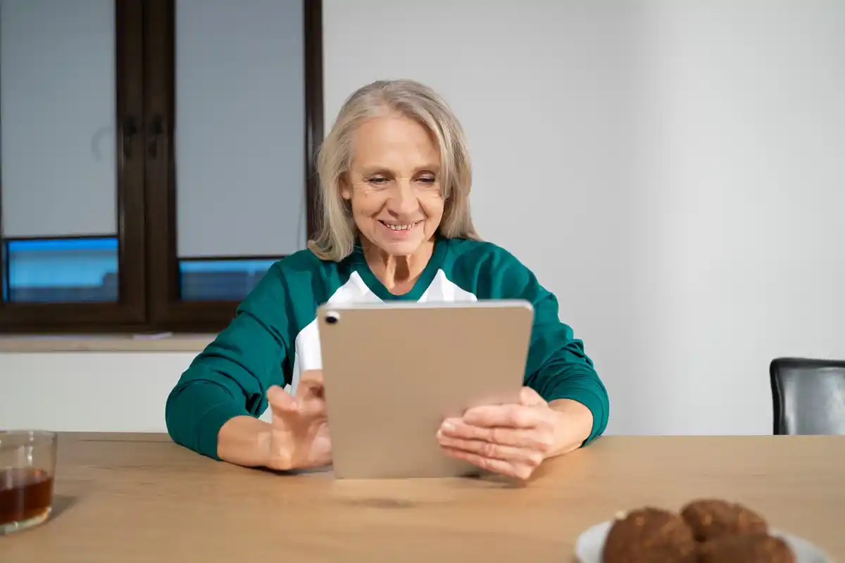 elderly woman using tablet indoors