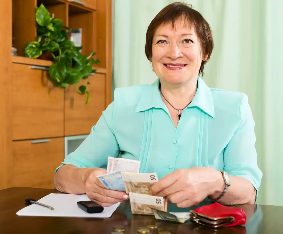 smiling czech grandmother saving money kitchen