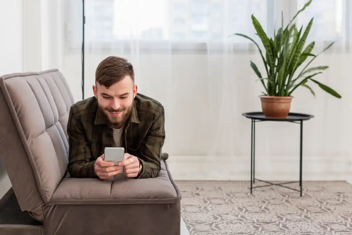 Czech man distracted by phone in living room, feeling unfocused