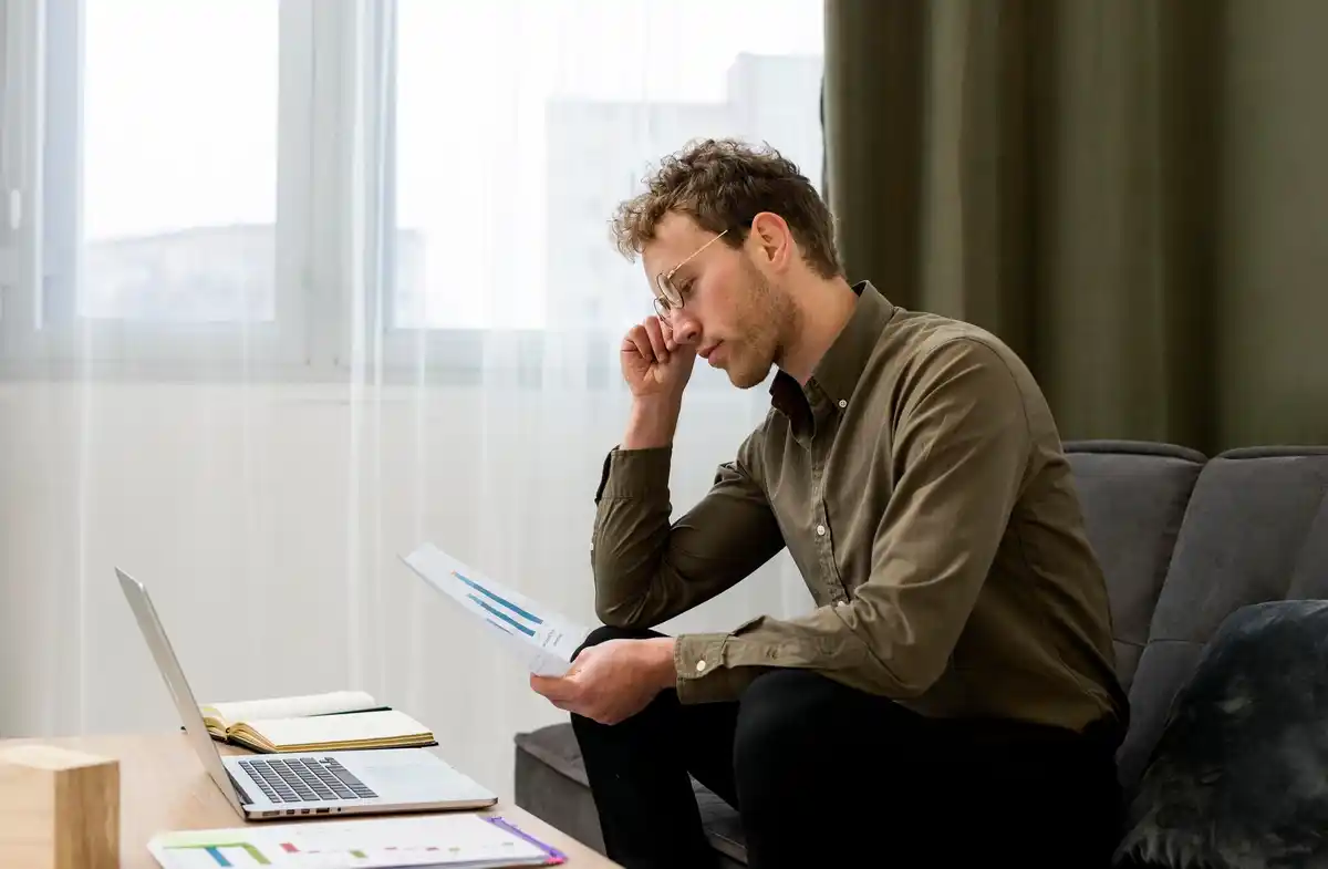 man stressed trying to work on multiple tasks czech office