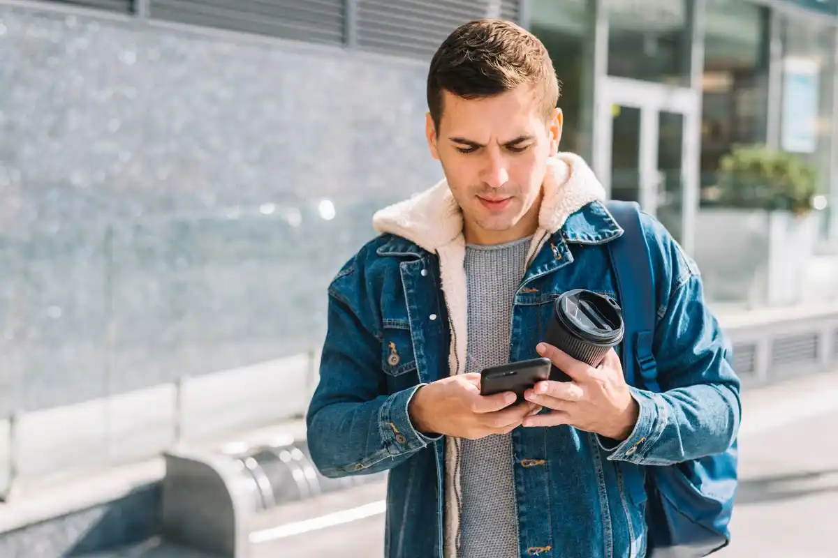young man using phone to pay in brno market