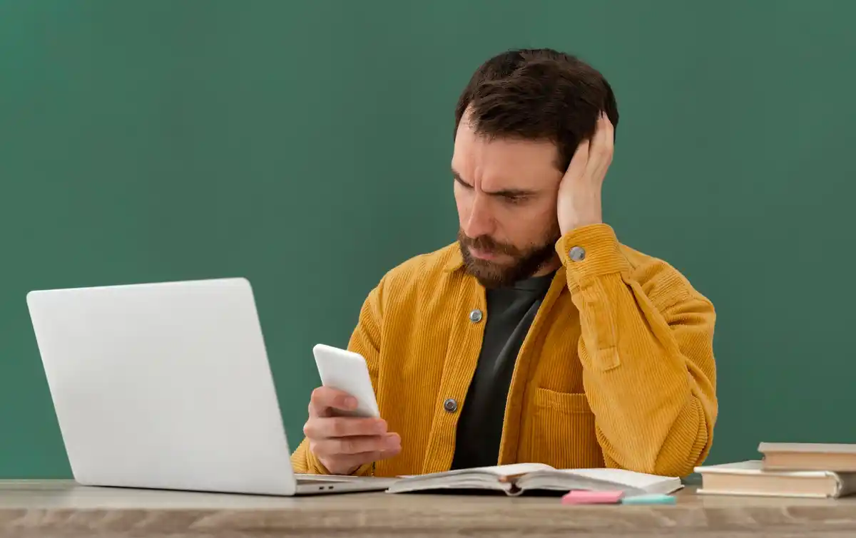 stressed office worker multitasking computer smartphone