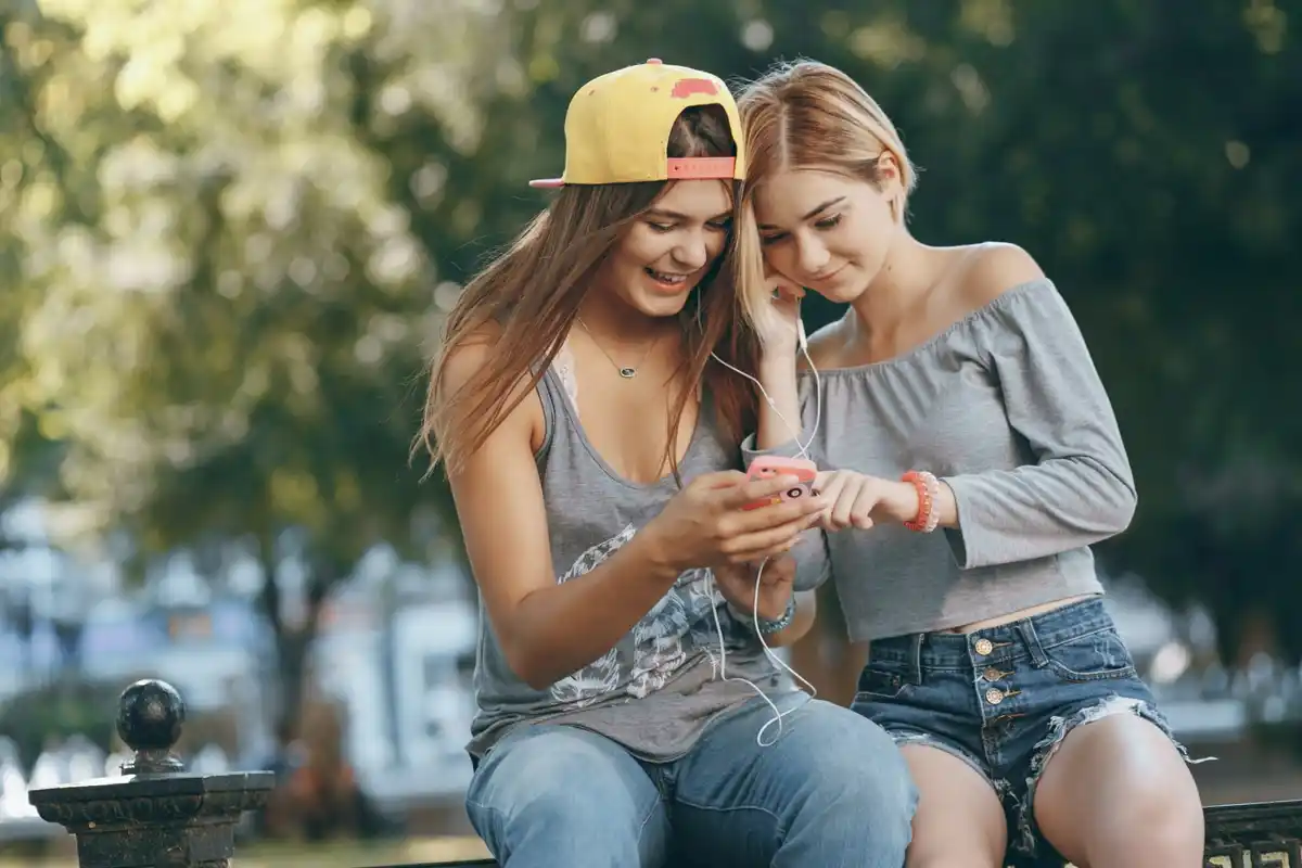 czech teenagers listening music from mobile phone outdoors