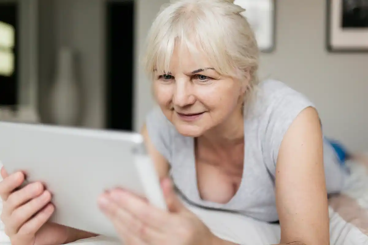elderly woman using tablet at home