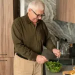 senior man cooking healthy meal kitchen Czech