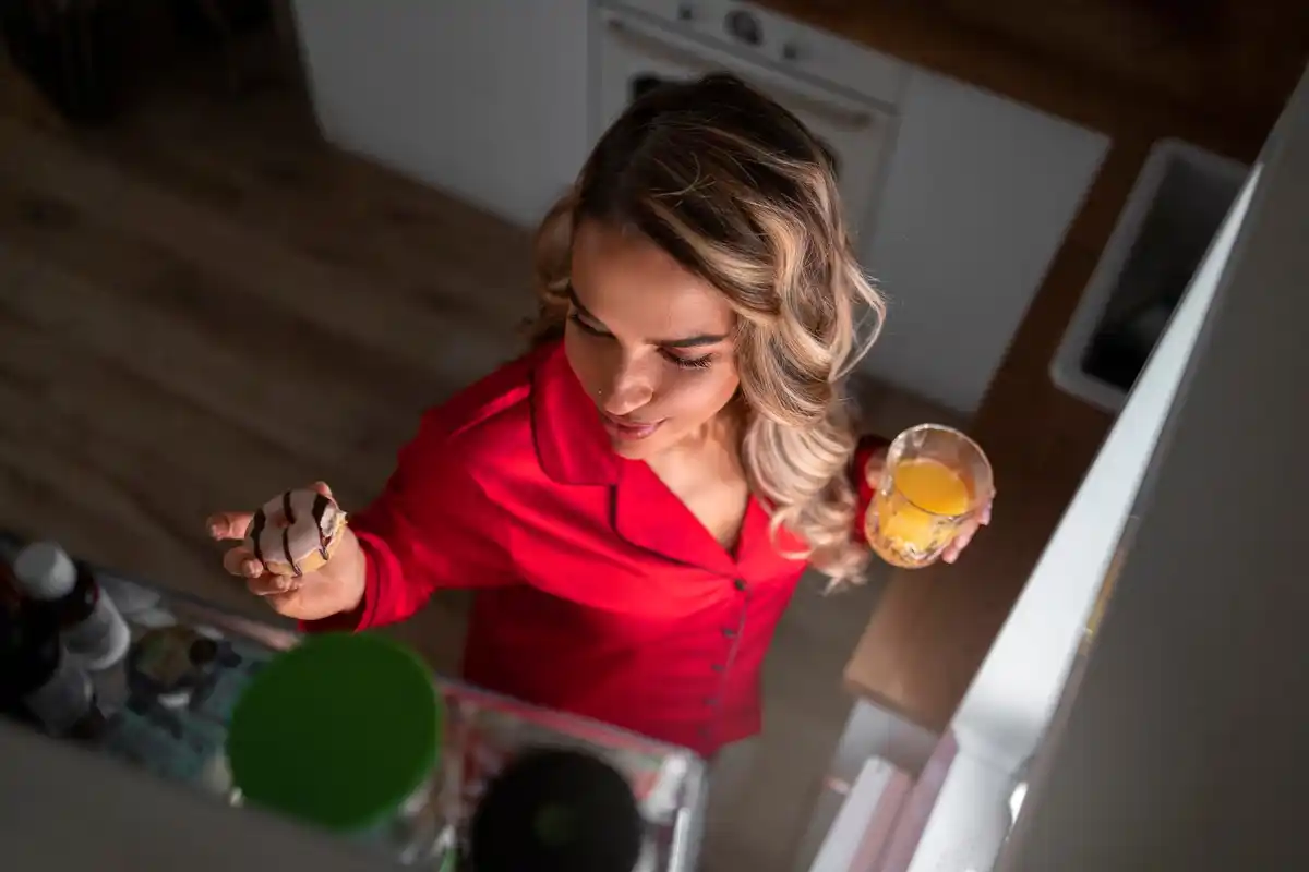 woman adding ice cubes into washing machine modern kitchen