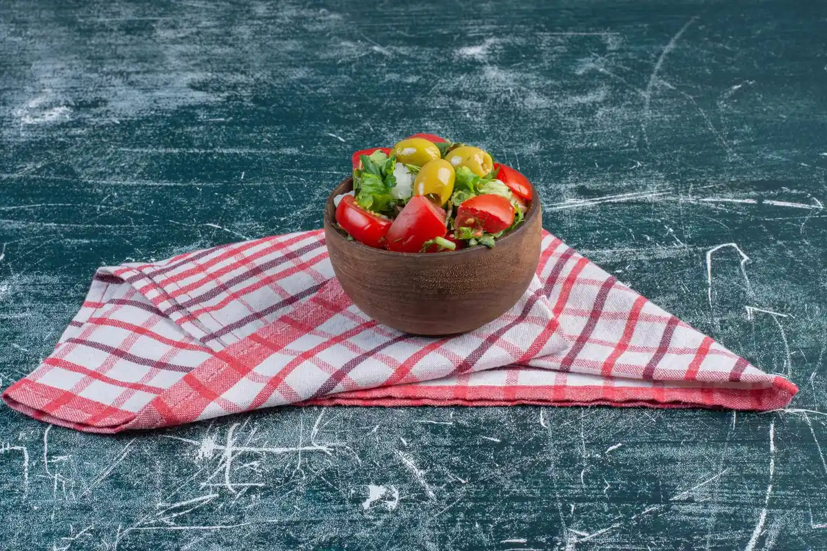 fresh salad stored in glass bowl with paper towel