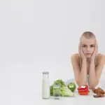 sad woman eating low carb small salad scale measuring tape