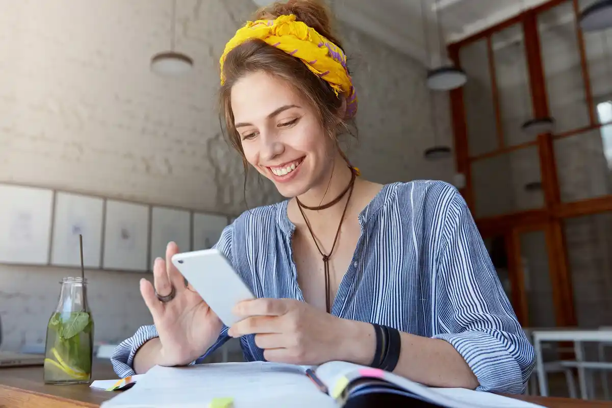 young person managing finances smartphone Czech