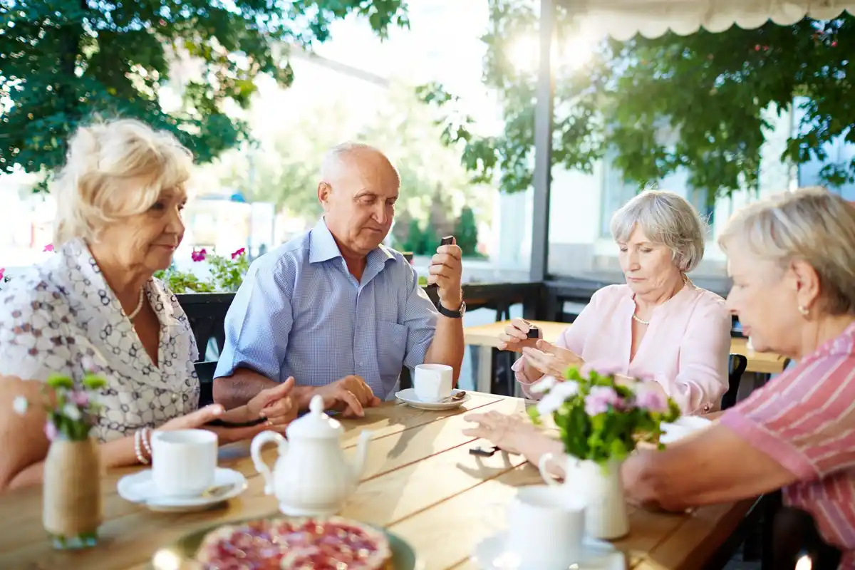 Czech seniors enjoying breakfast at terrace overlooking mountains